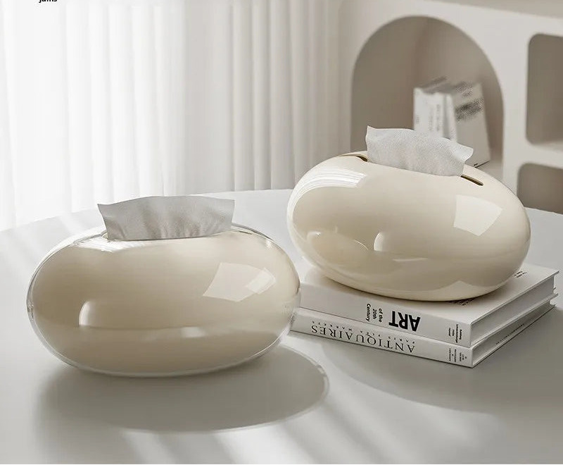 Two white tissue paper holders on a table with text about rounded edges and smooth extraction.