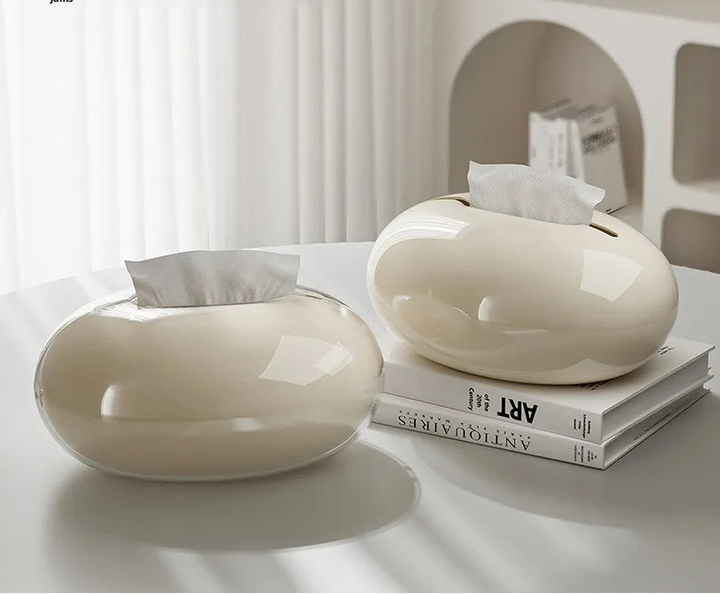 Two white tissue paper holders on a table with text about rounded edges and smooth extraction.